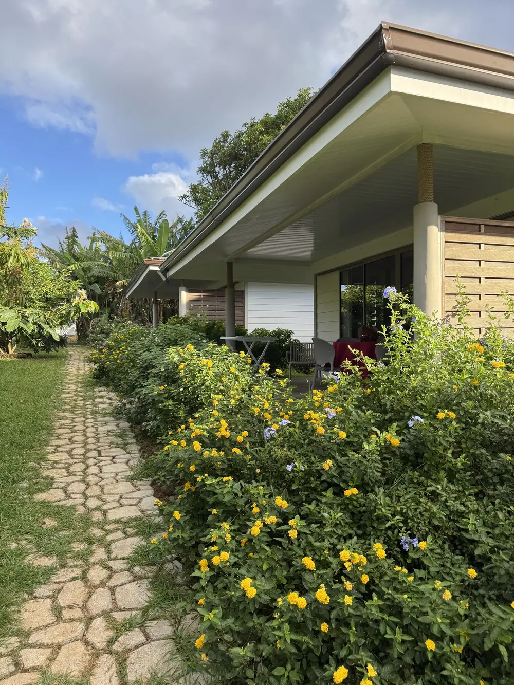 Allée pavée fleurie menant aux bungalows