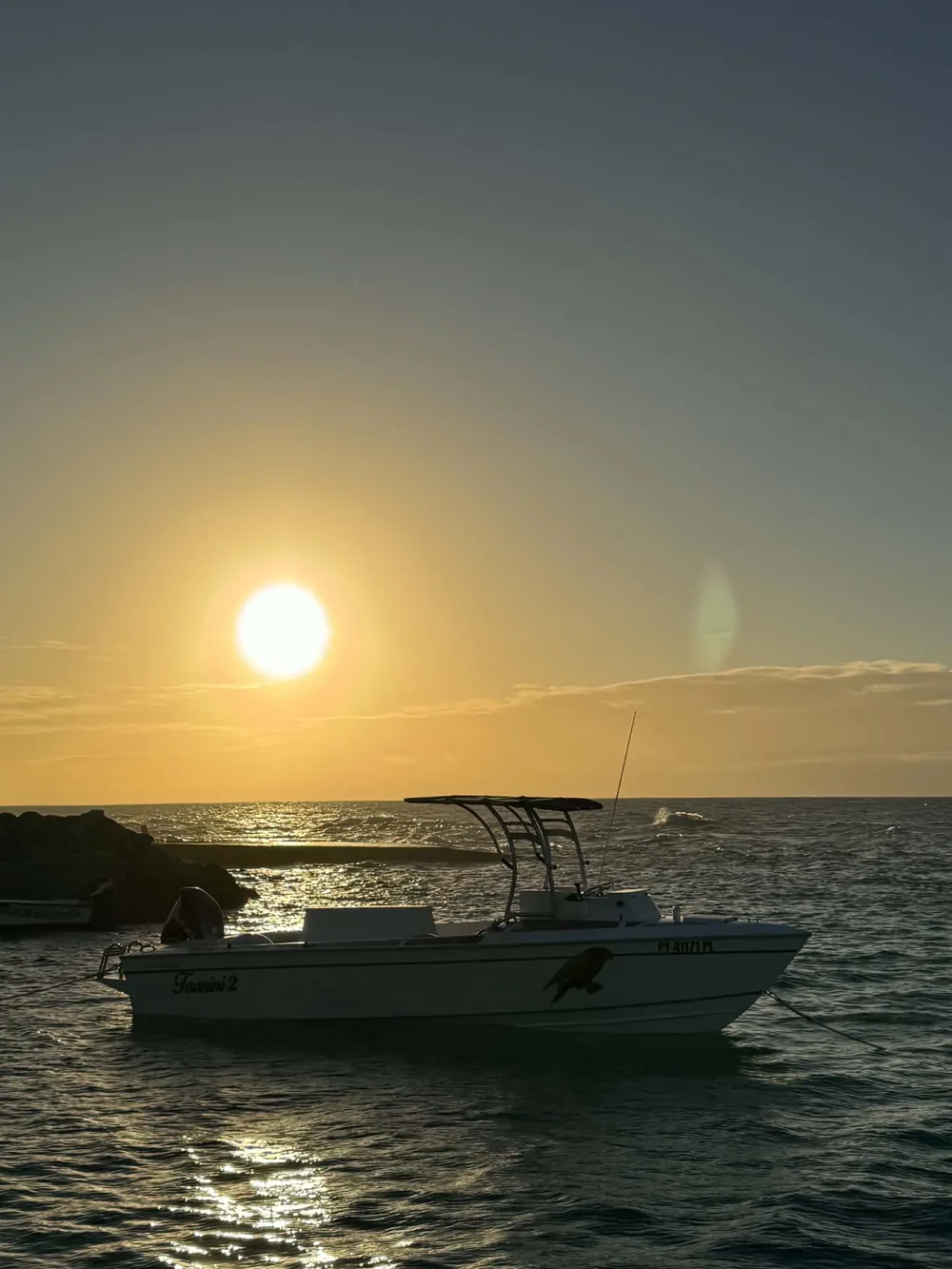 Le bateau au mouillage au coucher du soleil, au large de Rimatara