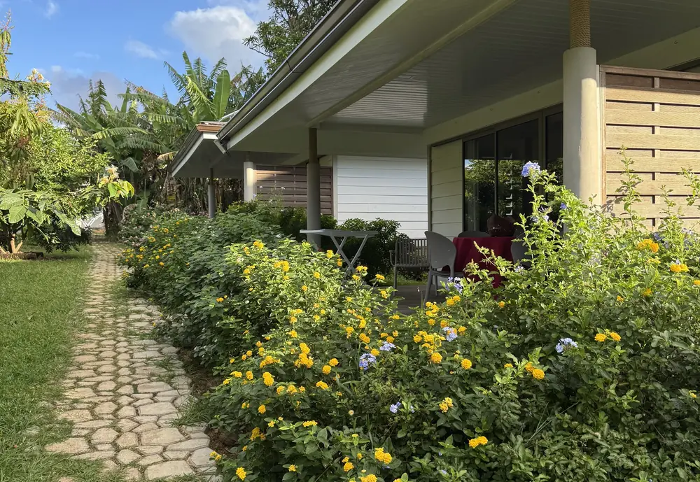 Les trois bungalows alignés le long de l'allée pavée et fleurie